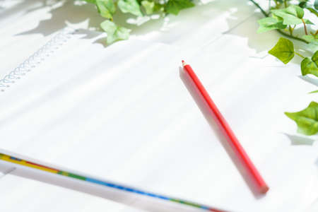 Colored pencils and sketchbook on wooden tableの写真素材