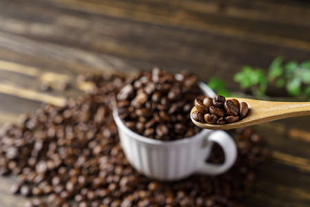 Coffee beans and cup on wooden table