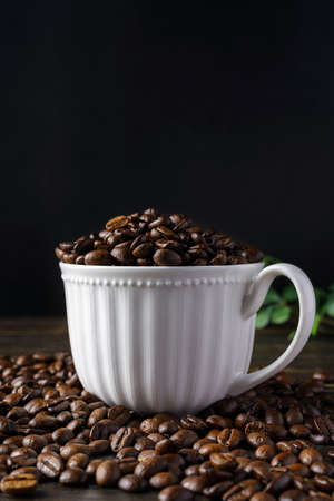 Coffee beans and cup on wooden table