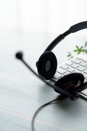 Headset and computer keyboard on wooden tableの写真素材
