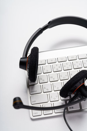 Headset and computer keyboard on white backgroundの写真素材