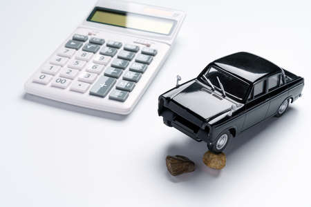 Calculator and broken car toys on white background