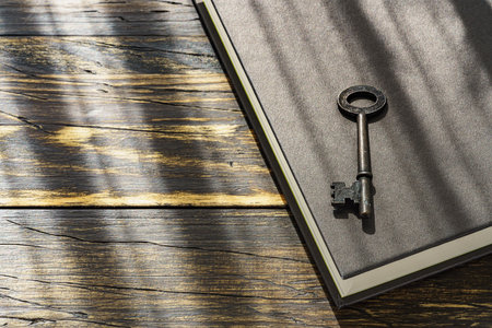 Vintage key and hardback book on wooden tableの写真素材
