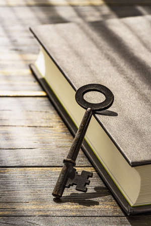 Vintage key and hardback book on wooden tableの写真素材