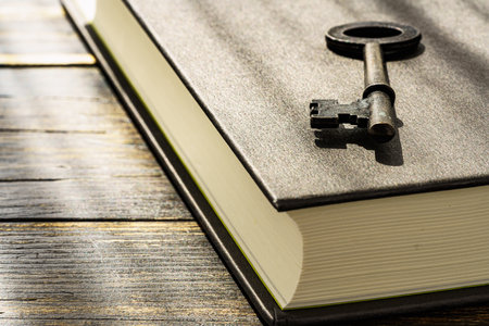 Vintage key and hardback book on wooden table