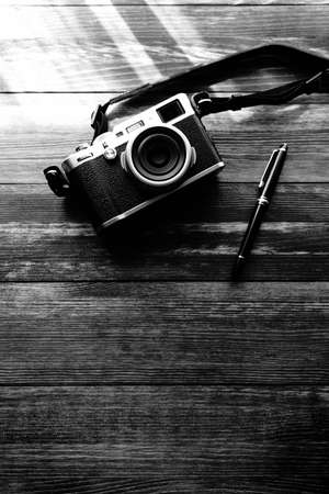 Old style digital cameras and pen on wooden tableの写真素材
