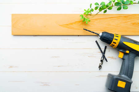Drill bits on wooden table. (Closeup of drill and hole in the piece of wood)の写真素材