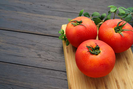 Fresh tomatoes isolated on wooden table
