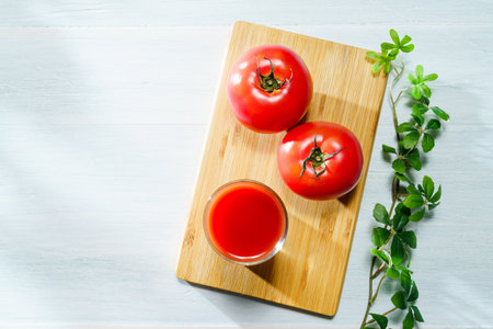 Tomato juice in glass on wooden tableの写真素材