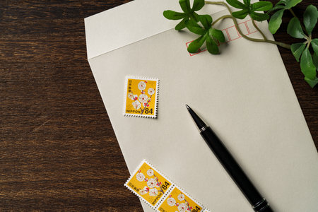 Envelope and Japanese postage stamp on wooden tableの写真素材
