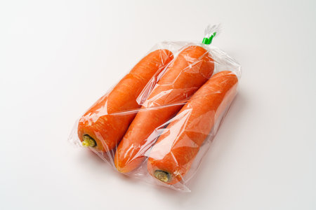 Carrots in a plastic bag on white backgroundの写真素材