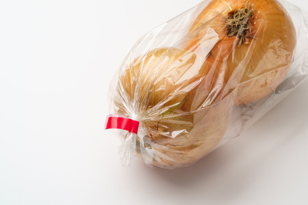 onions in a plastic bag on white backgroundの写真素材