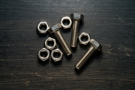 Steel nuts and bolts closeup on wooden tableの写真素材