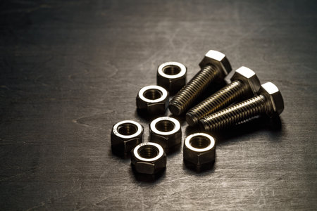 Steel nuts and bolts closeup on wooden tableの写真素材