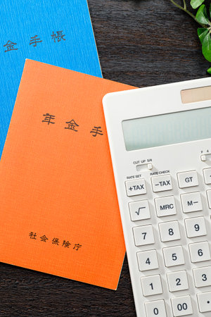 Japanese pension insurance booklet on wooden table. (Written 'pension book')の写真素材