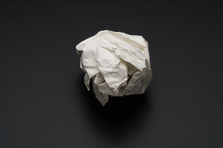 Crumpled paper ball on dark backgroundの写真素材
