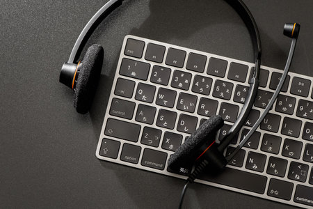 Headset and computer keyboard on dark background