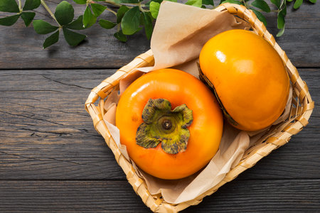 Fresh ripe persimmons on wooden tableの写真素材