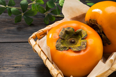 Fresh ripe persimmons on wooden tableの写真素材
