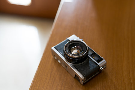 Old film camera resting on wood surface