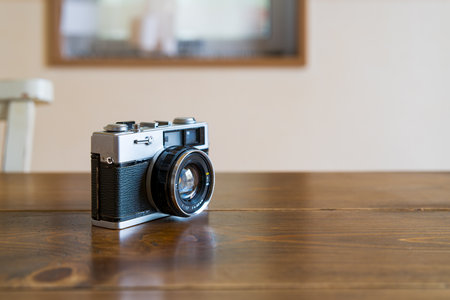 Old film camera isolated on wooden table