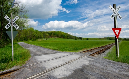 Country Railroad Crossing:  A narrow gravel road crosses a set of railroad tracks in rural Virginia.