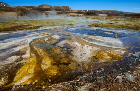  Hot Springs:  Mineral water emerges at near boiling temperatures and flows across colorful mud plains in an area of geothermal activity in southern Iceland.の写真素材