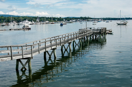 Long Pier:  A wooden walkway extends far across the shallow end of a bay in Maine.の写真素材