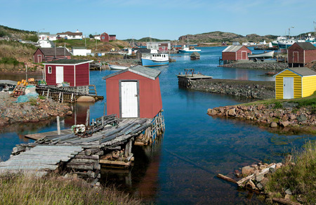 Newfoundland Fishing Village:  Fishing shanties sit on rustic wooden piers and rock jetties that extend into a small harbor on the north coast of Newfoundland.の写真素材