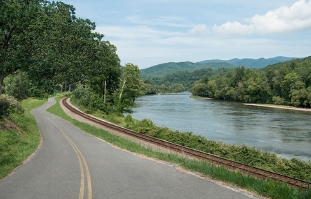 Appalachian Transport Routes:  Railroad tracks and a country road follow the edge of a river in the mountains of eastern Tennessee.の写真素材