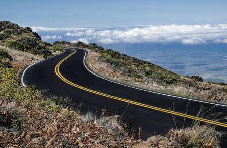 Maui Mountain Road:  The road from the top of Mt. HaleakalÄ begins above the clouds and descends through arid terrain to a tropical valley below.の写真素材