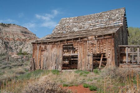 Old Wooden Barn:  A barn with missing shingles and side boards weathers in the sunshine of southern Utah.の写真素材