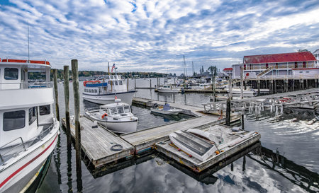 Small New England Harbor Town:  Boats for fishing, sailing and touring gather beneath a cloudy October sky as evening approaches in Boothbay Harbor, Maine.の写真素材