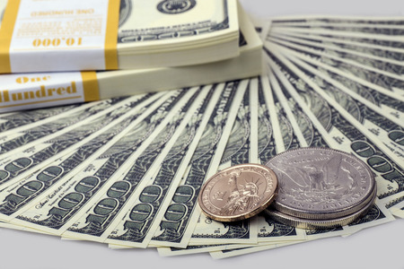 Banknotes on hundred dollars and three coins on the isolated grey background