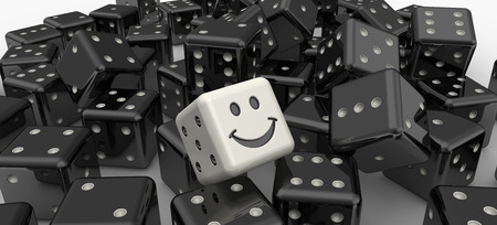 Heap of black dices as background with white smiley cubeの写真素材