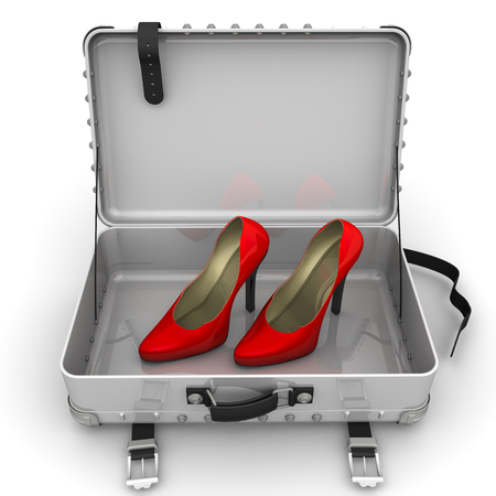 Red female shoes with high heels are in an open suitcaseの写真素材