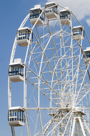 Fragment of a white ferris wheel against a blue sky backgroundの写真素材