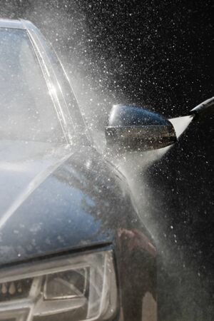 Water and foam under pressure flies toward the car body. Close-up viewの写真素材