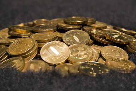 Many Russian ten-ruble coins in a heap on a woolen surface