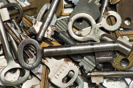 Heap of different keys to the locks lie on a white surfaceの写真素材