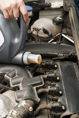 The engine compartment, canister and engine oil are poured into the oil filler neck of the engineの写真素材