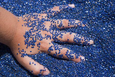 A lot of blue glue rhinestones and the kids handの写真素材