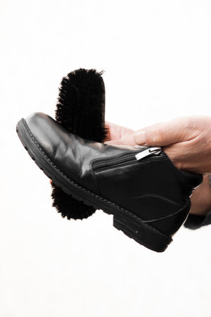 Leather shoe care. Cleaning leather shoes with black shoe creamの写真素材