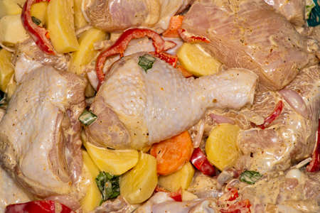 Cooking chicken meat with potatoes. Marinated chicken meat with potatoes, carrots and paprika for oven cookingの写真素材
