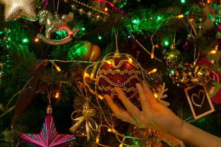 Fragment of a decorated Christmas tree. Spruce tree decorated with New Year's ornaments toys, balls ...