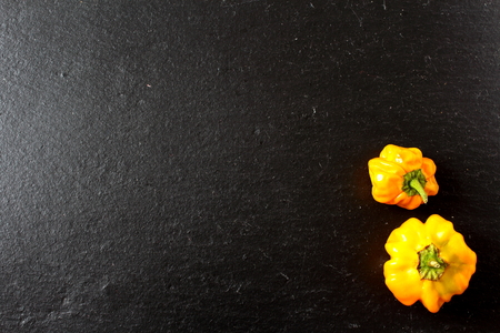 yellow scotch bonnet chili peppers on a slate plateの写真素材