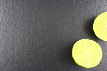 fresh lime fruit on a slate plate as a food background textureの写真素材
