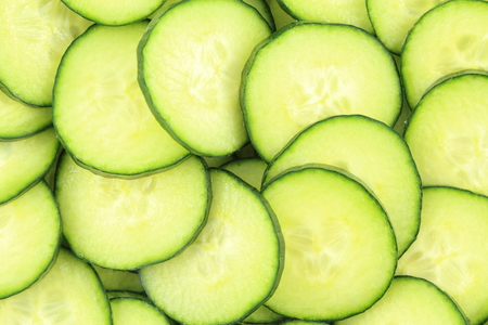 slices of fresh green cucumbers as a food background textureの写真素材
