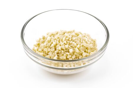 minced almonds in a small glass bowl isolated on white copy spaceの写真素材