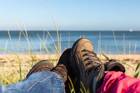 Leg with walking shoes on the beachの写真素材